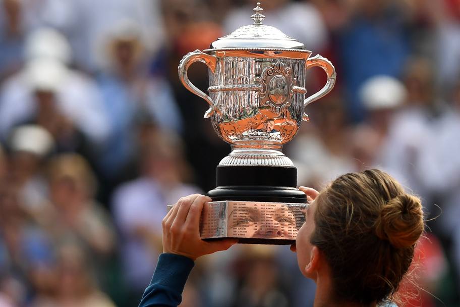 Gli occhi di Simona Halep riflessi nel piedistallo del trofeo alzato sul Centrale del Roland Garros. Afp